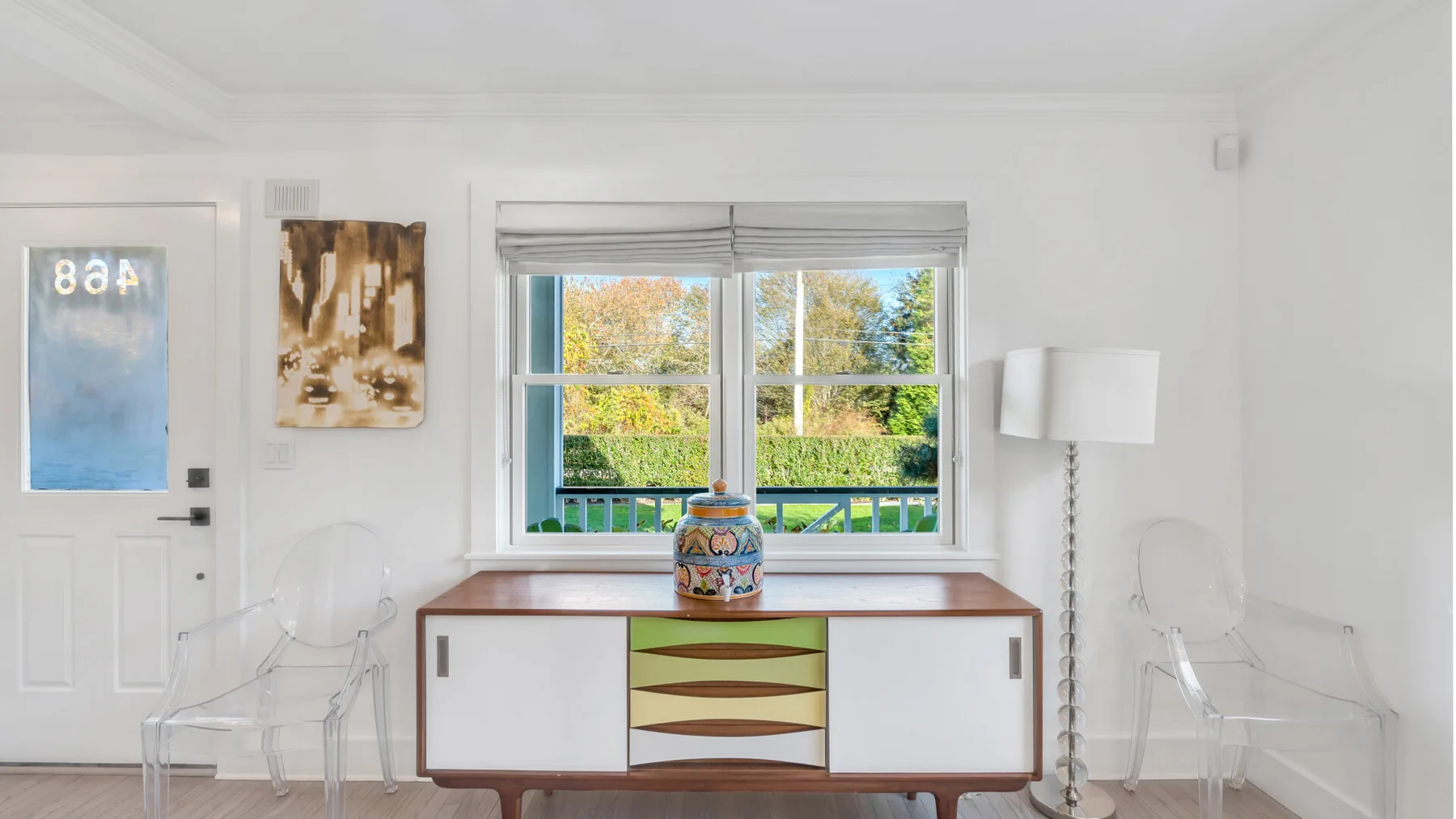 Una habitación luminosa con un escritorio bajo una ventana que da a la vegetación.