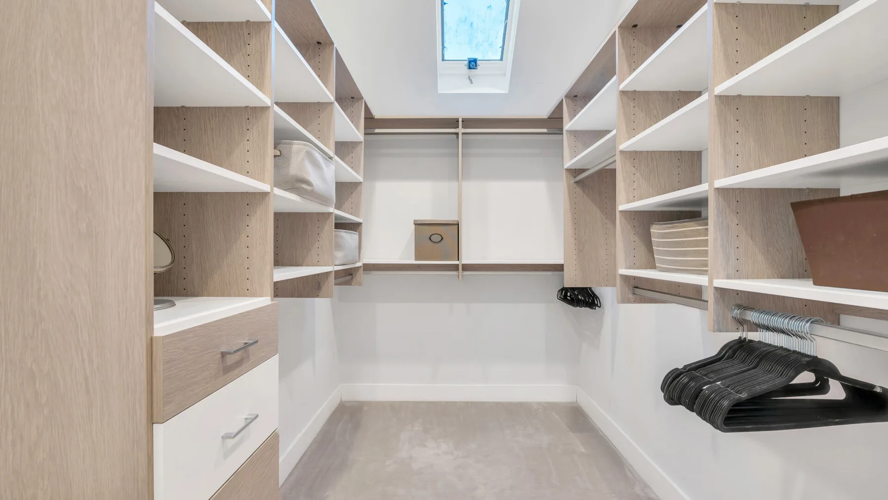 Un vestidor con estantes abiertos, cajones y espacio para colgar ropa.