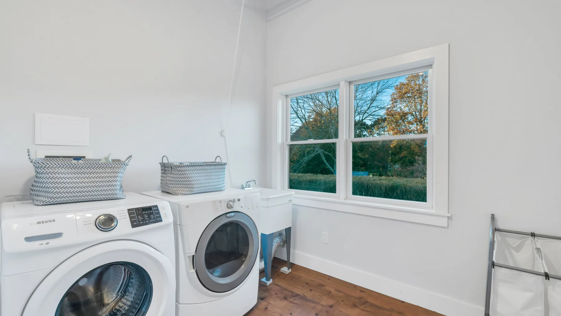 Un cuarto de lavandería con lavadora y secadora junto a una ventana.
