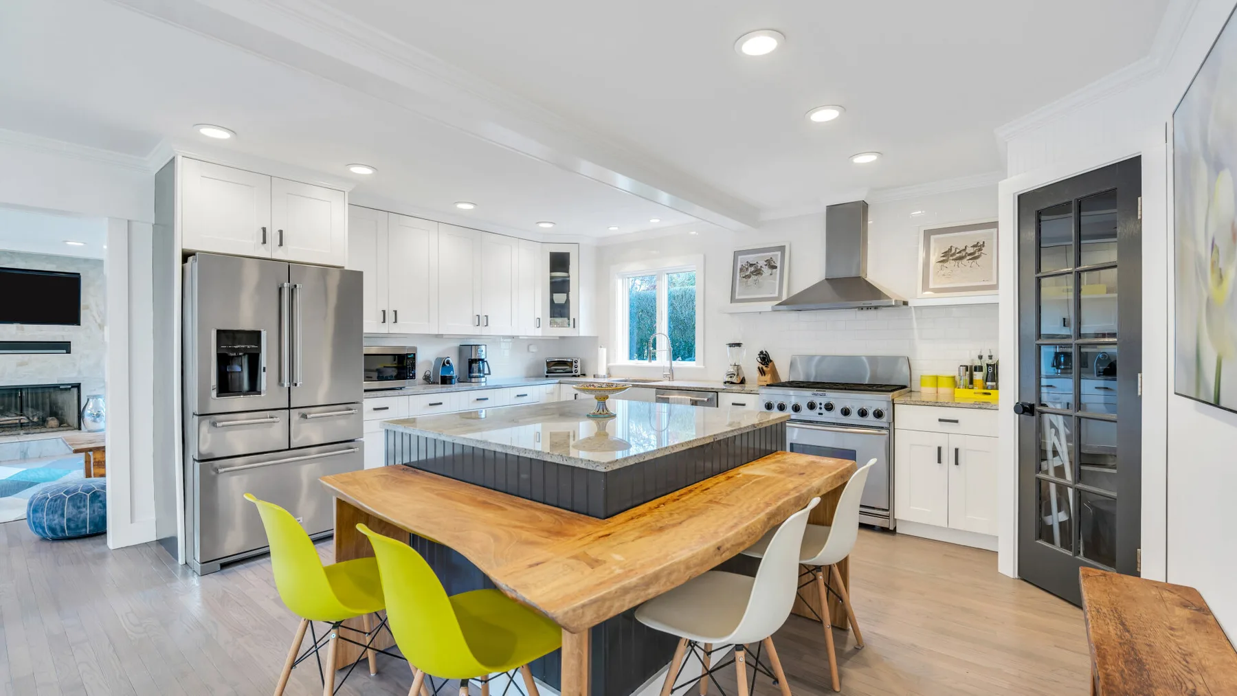 Una cocina luminosa con una gran isla y asientos junto a la encimera.