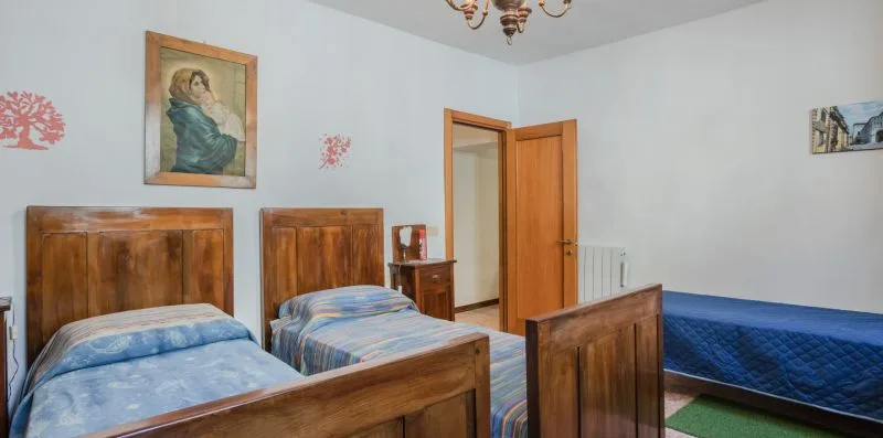 Un dormitorio con camas de madera y cuadros en las paredes.
