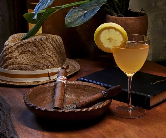 Cocktail and cigar at a table