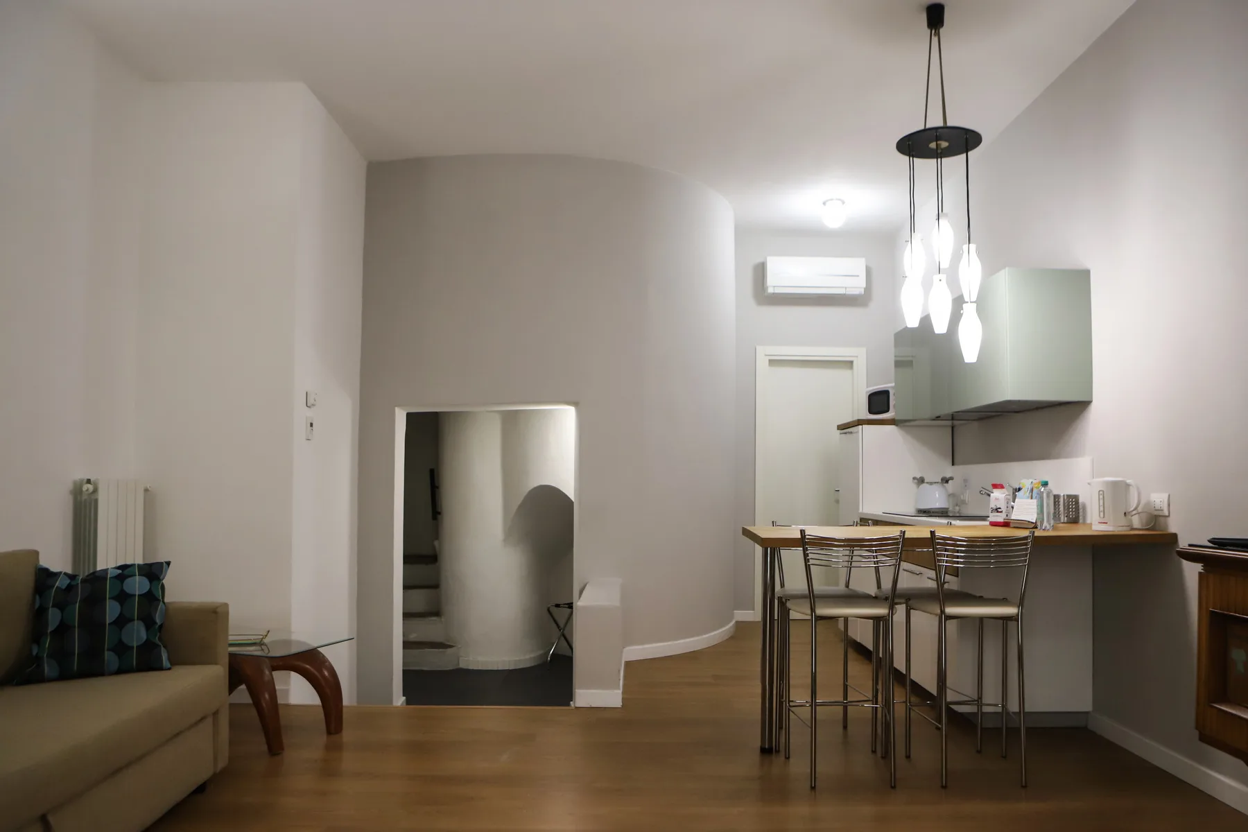 Una cocina y comedor de concepto abierto con una barra y luces colgantes.