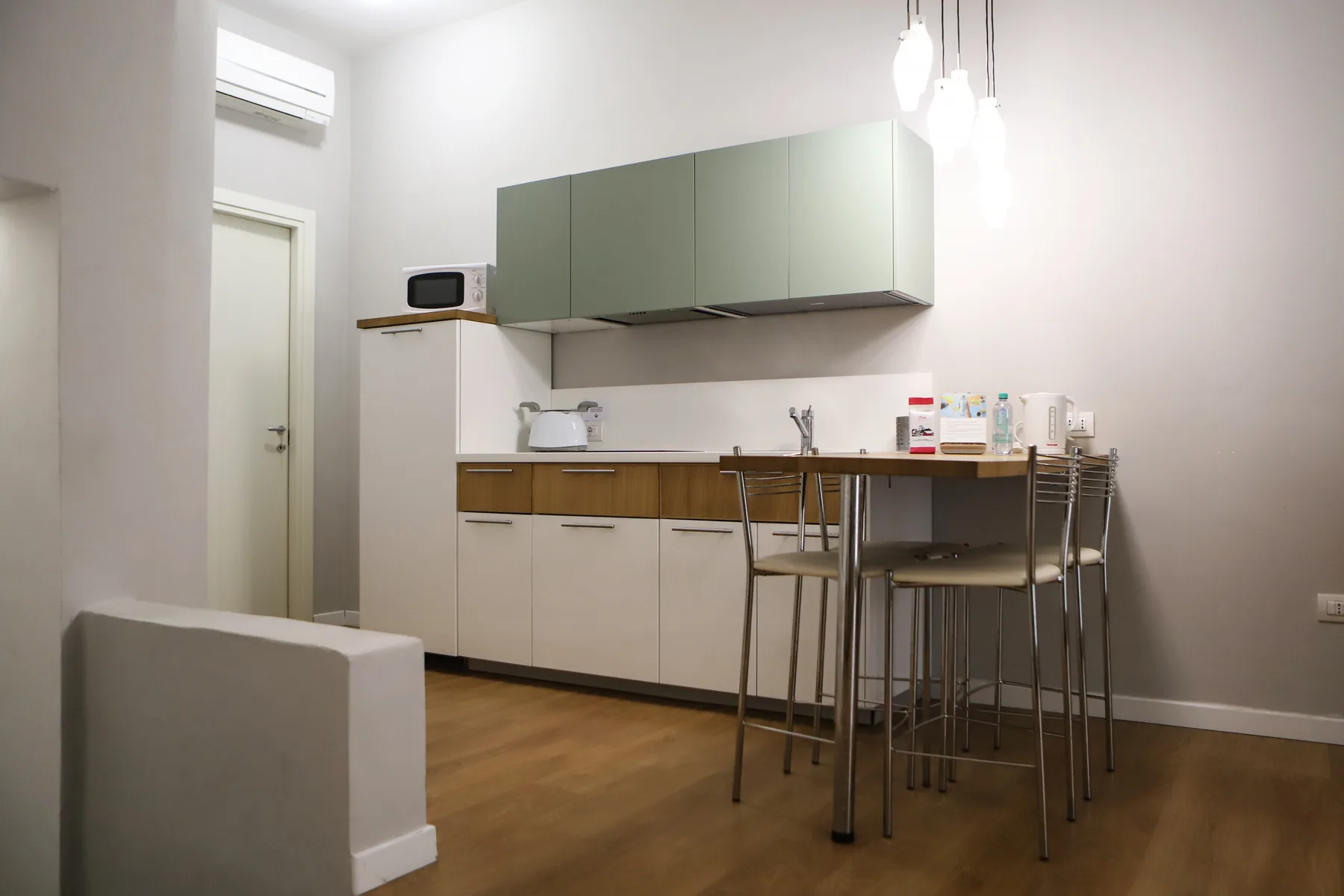 Una cocina moderna con armarios superiores, una encimera y asientos de barra.