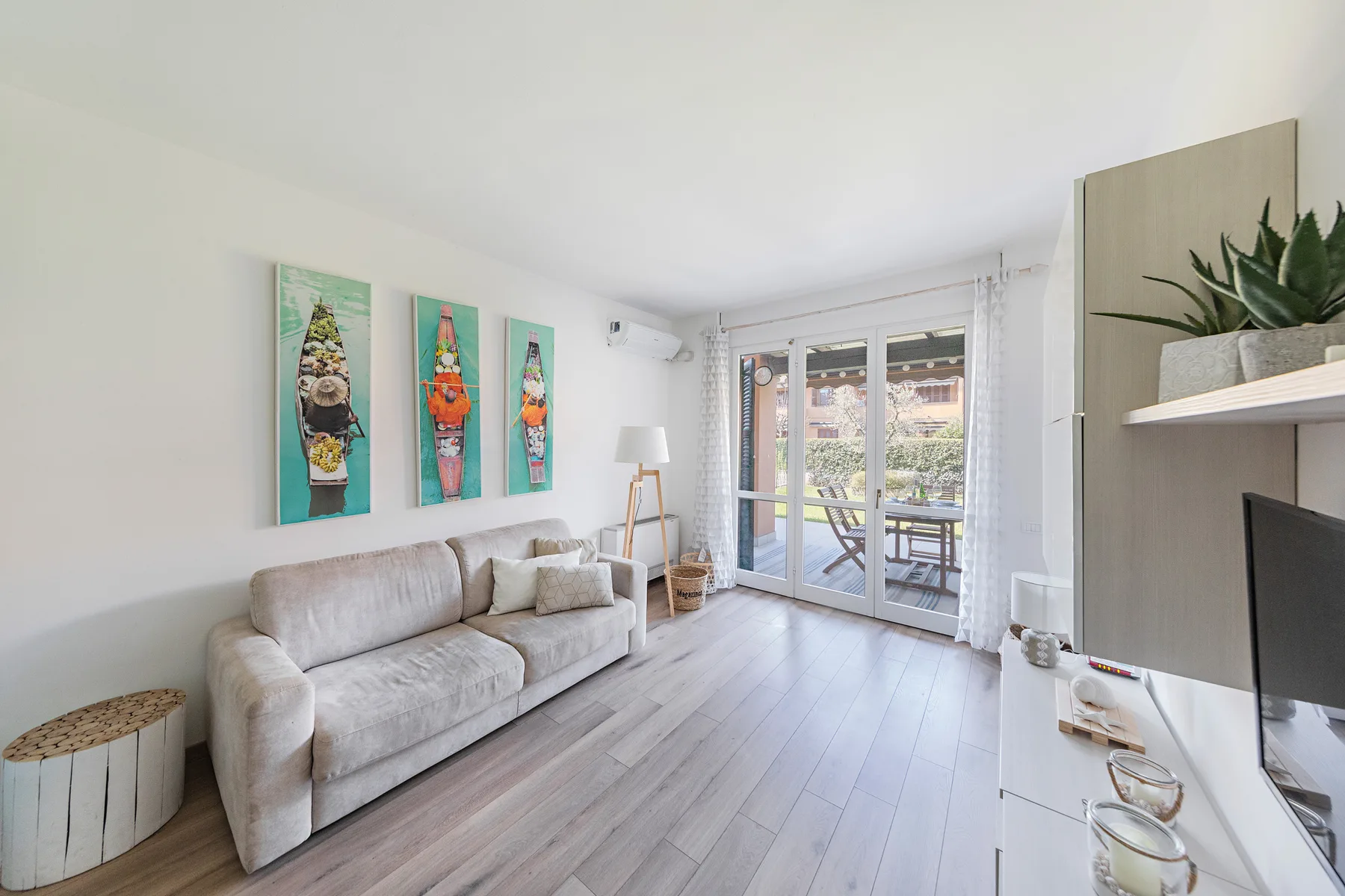 A bright living room with seating and glass doors opening onto a balcony.