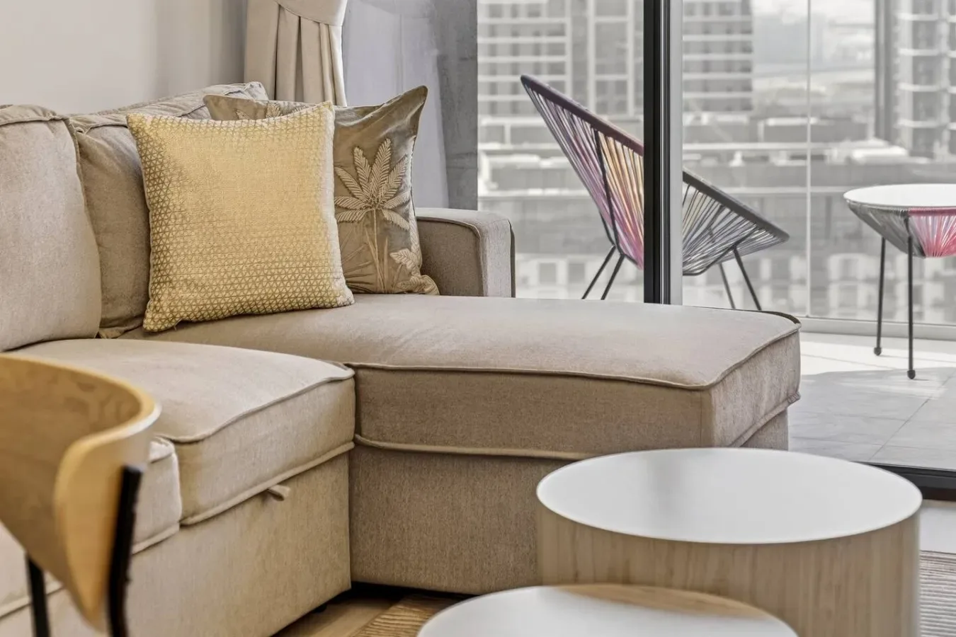 A bright living room with a sectional sofa and large windows.