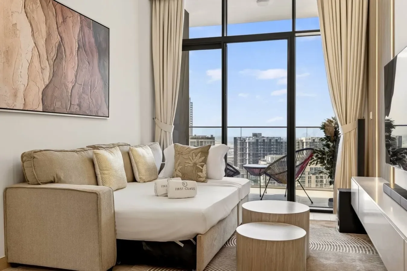 A living room with seating beside large windows overlooking the city.