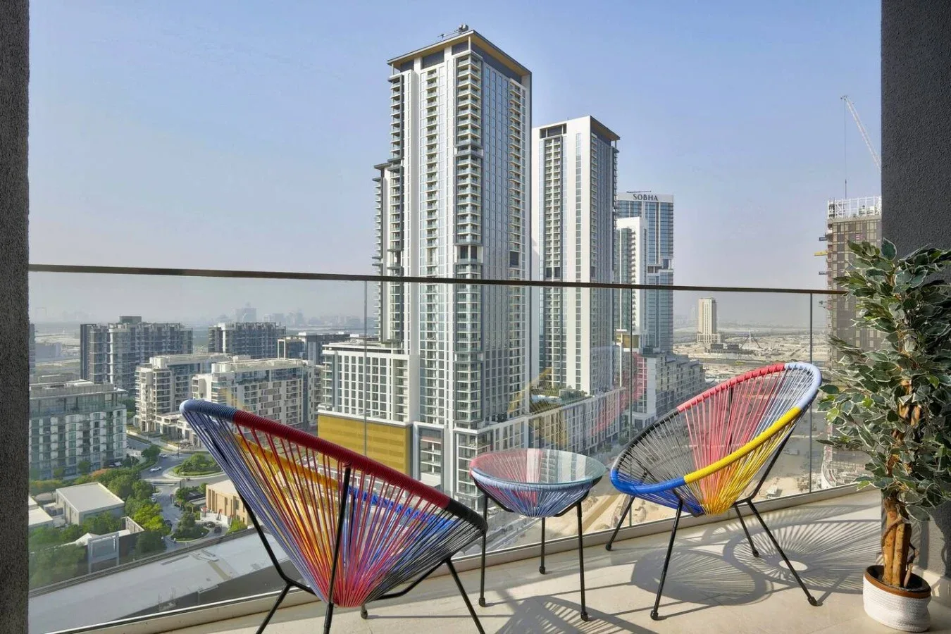A balcony seating area overlooks a city skyline.