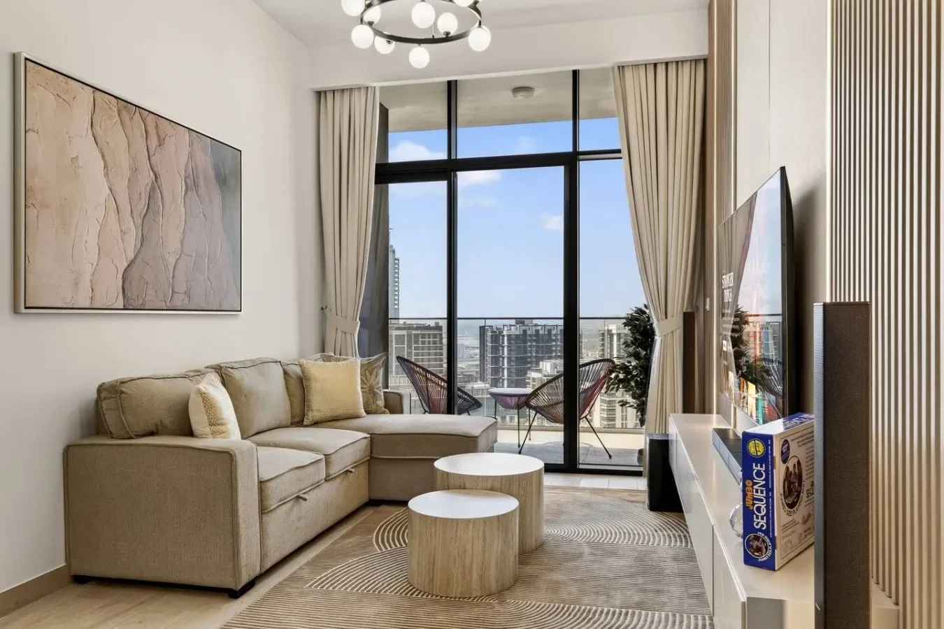 A bright living room with a sectional seating area and large windows overlooking the city.