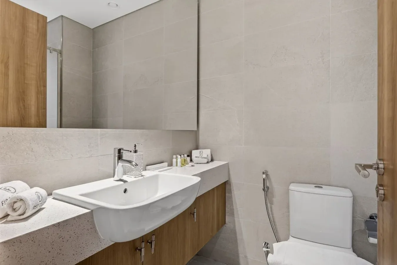 A modern bathroom with a sink, vanity, and toilet.