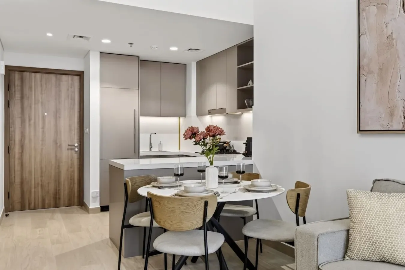 Un comedor con la mesa puesta está junto a una cocina compacta.
