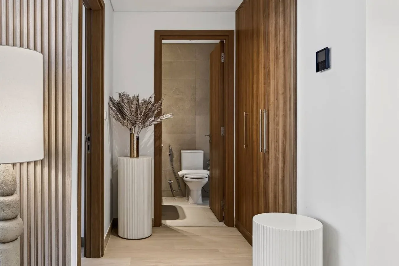 A bathroom doorway opens onto a tiled bathroom, with a toilet visible inside.