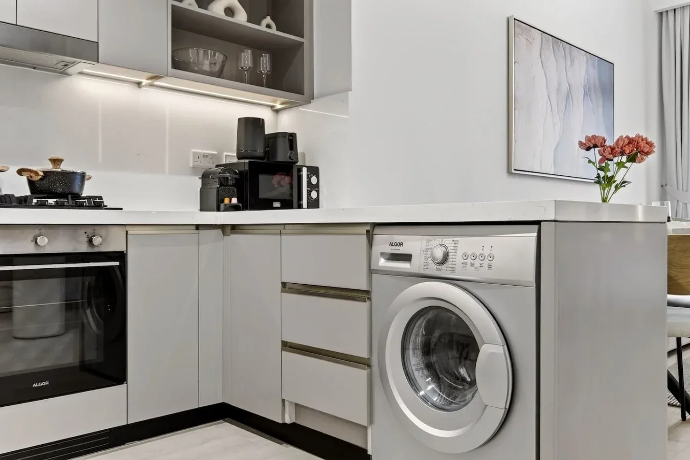 A modern kitchen with a washing machine beneath the counter.