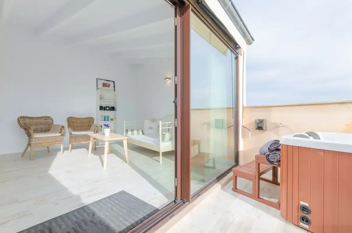 A bright lounge opens onto a terrace through large sliding glass doors.