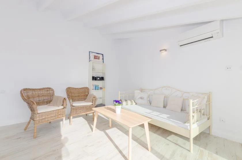 A bright sitting room with wicker seating and a low coffee table.