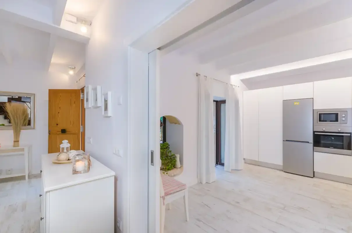 A bright kitchen with white cabinetry and a stainless-steel refrigerator.