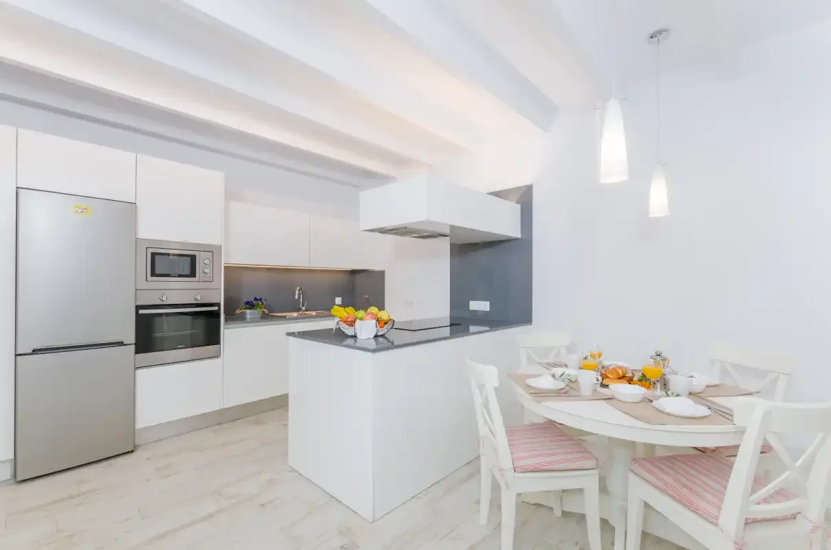 A bright kitchen and dining area with a white island and set table.