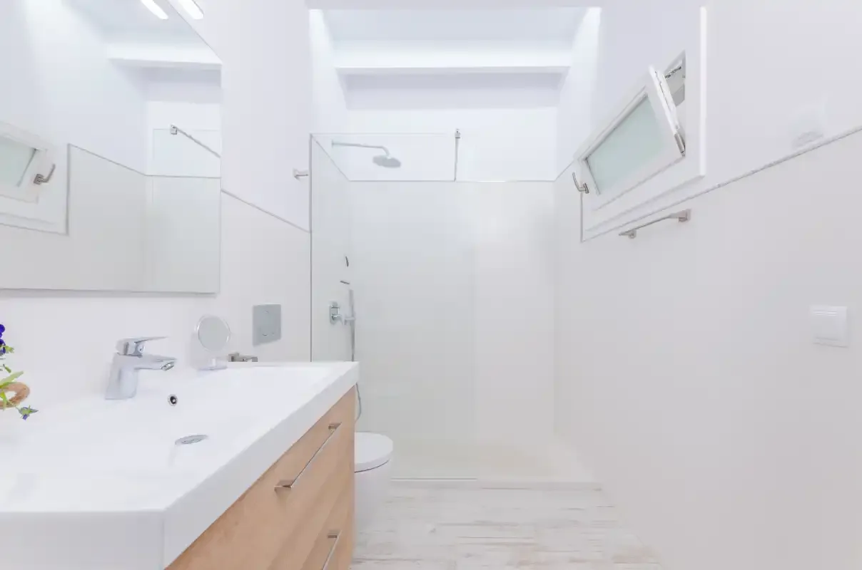 A bright bathroom with a vanity and shower.