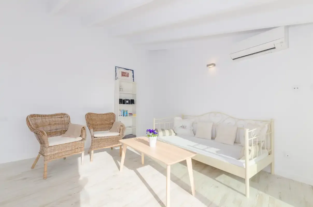 A bright living room with wicker seating and a white sofa.