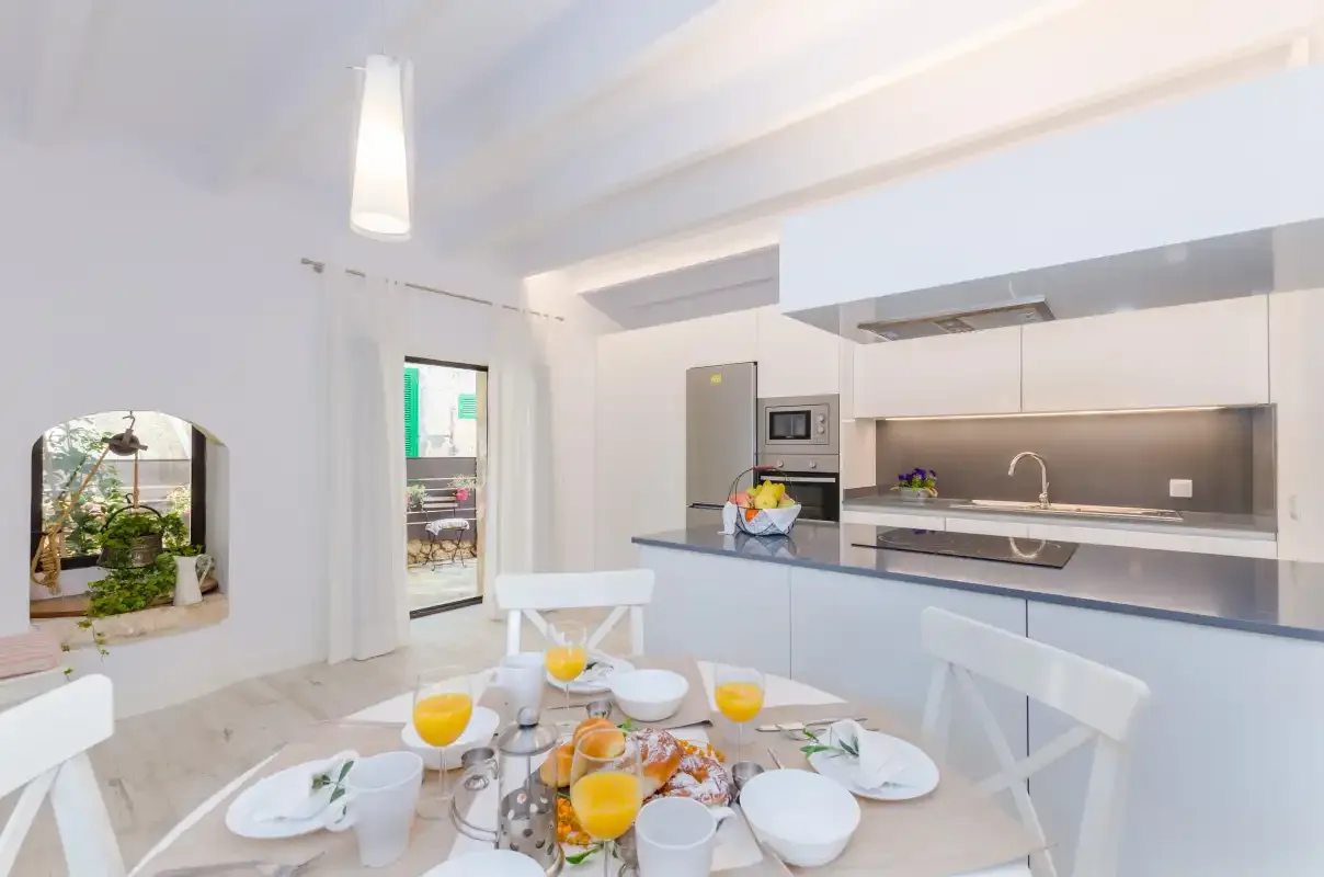 A bright dining area with a table beside a modern kitchen.