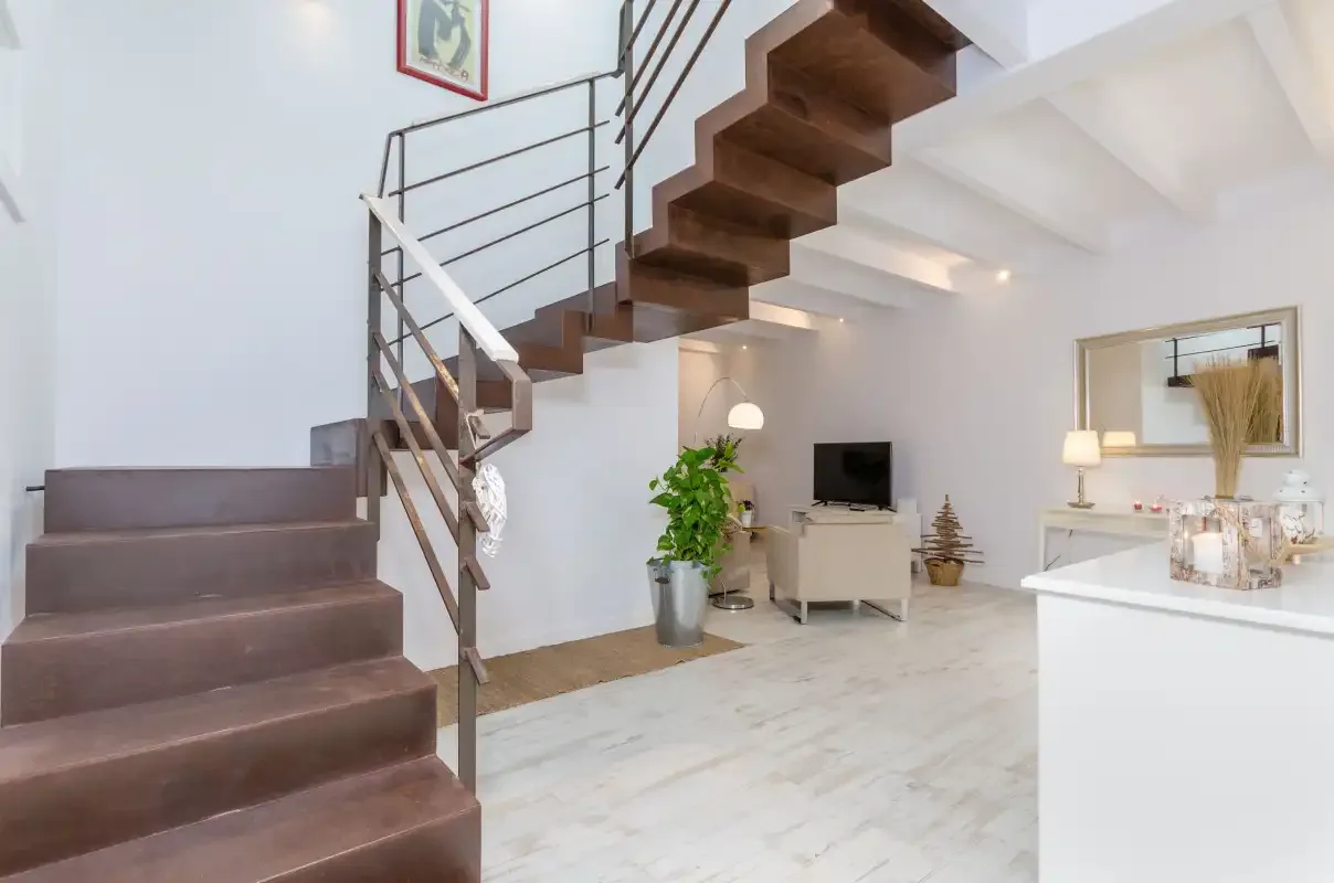 An open living area with a staircase, television, and small potted plant.