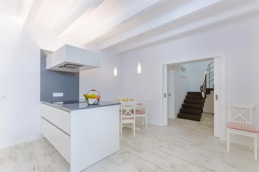 A bright kitchen and dining area opens onto a staircase.