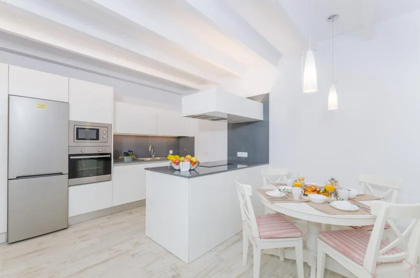 A bright kitchen and dining area with a central island and a set table.