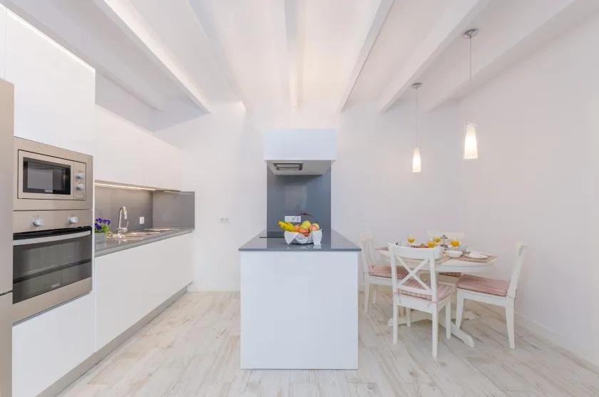 A bright kitchen and dining area with a central island and table.