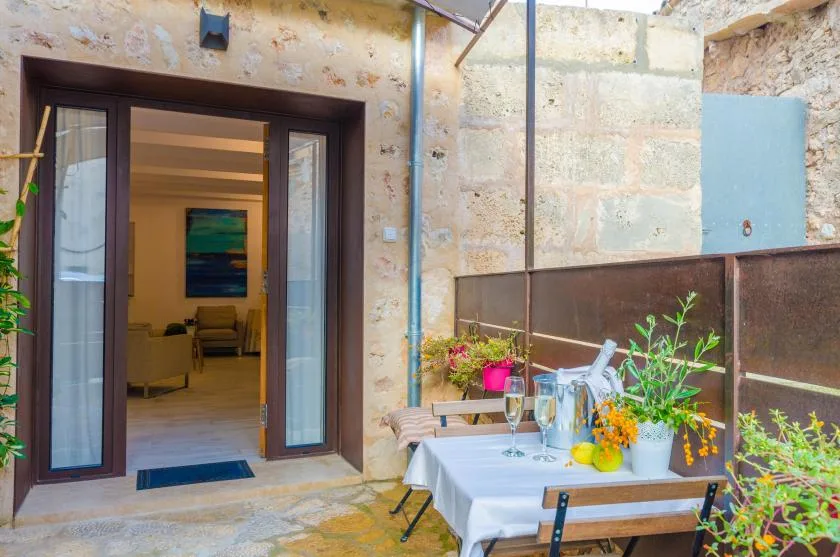 A stone patio dining area sits beside an open doorway to a living room.