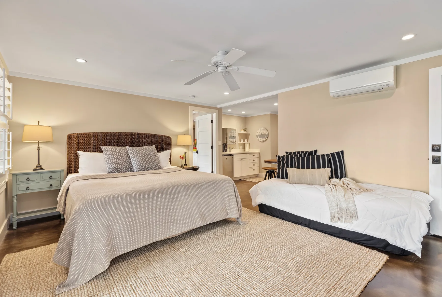 A bedroom with a large bed and a smaller bed beside it.