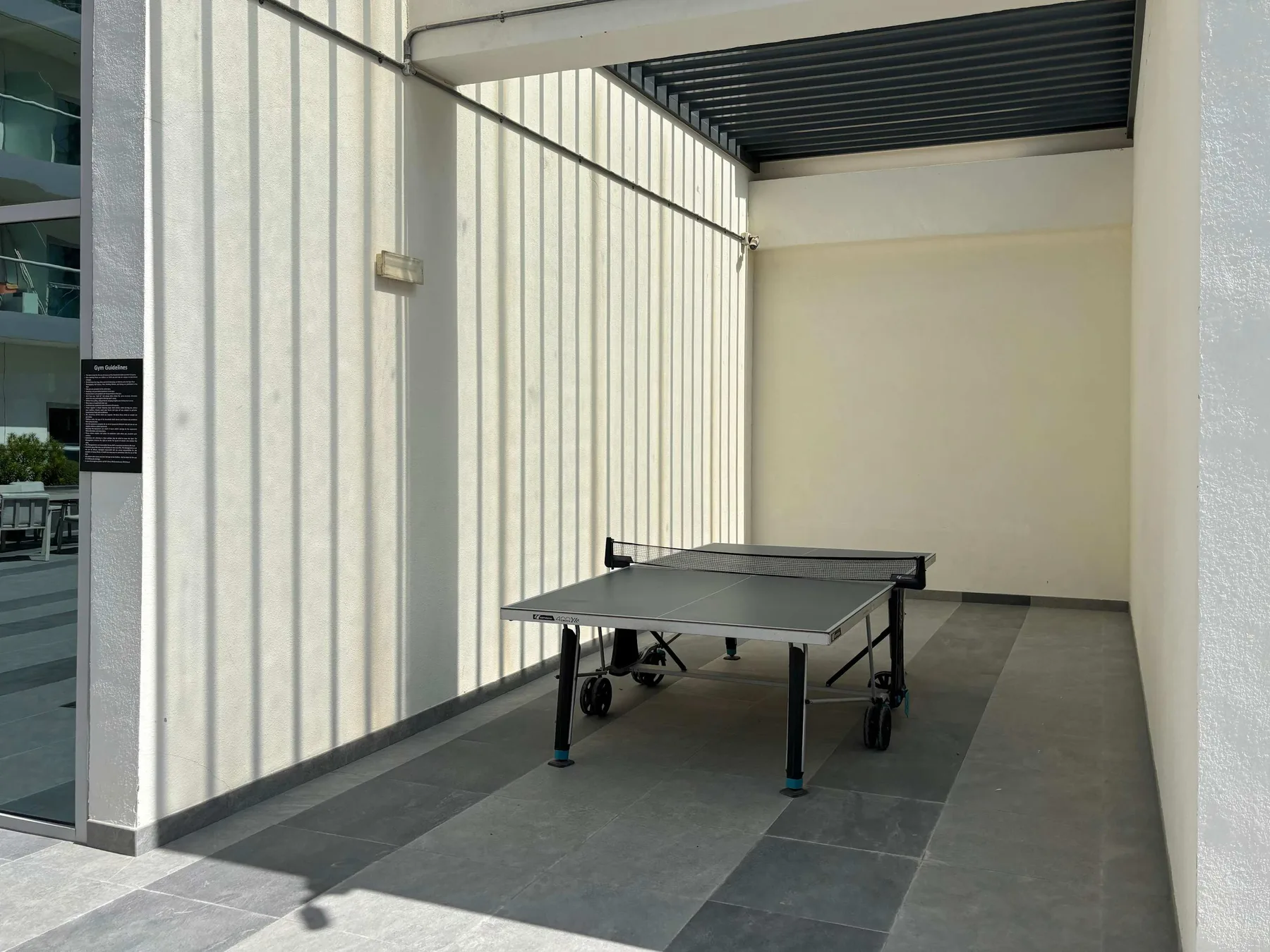 A covered indoor recreation area with a table tennis table.