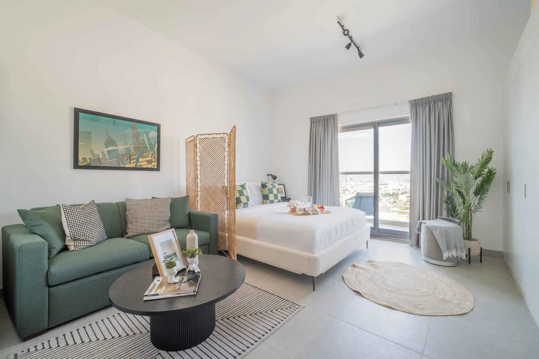 Dormitorio con una cama, un sofá y una ventana con cortinas.