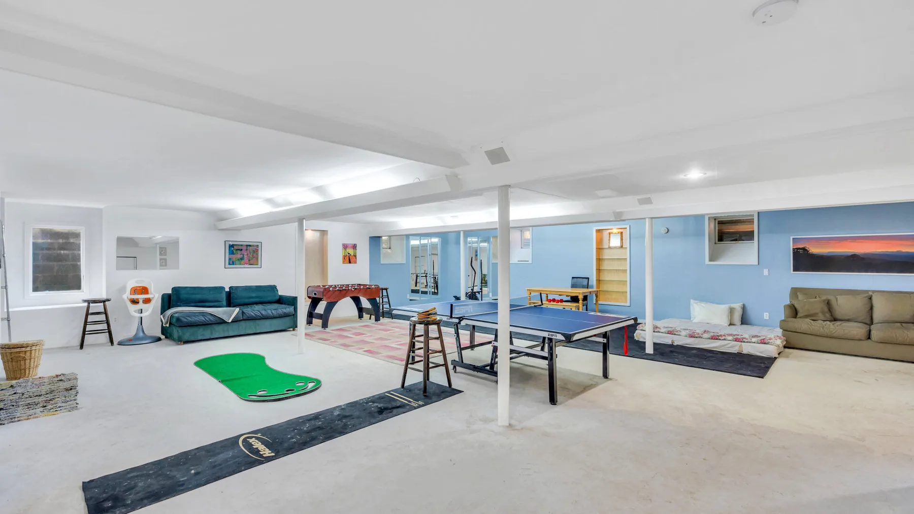 Una sala de recreación luminosa tiene billar, una mesa de ping-pong y asientos.
