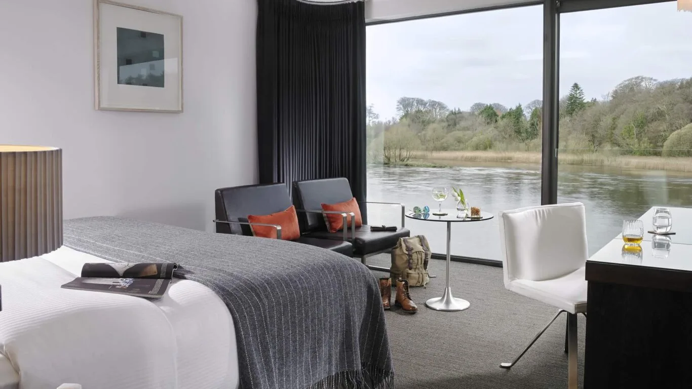 Habitación del hotel junto al río con zona de estar y vistas al río.