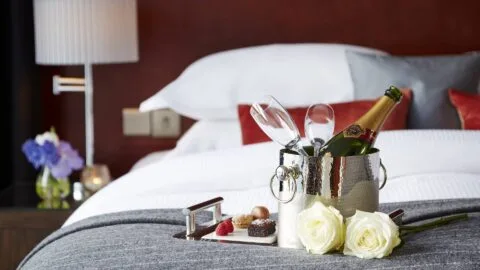 Habitación del hotel preparada con champán, bombones y flores.