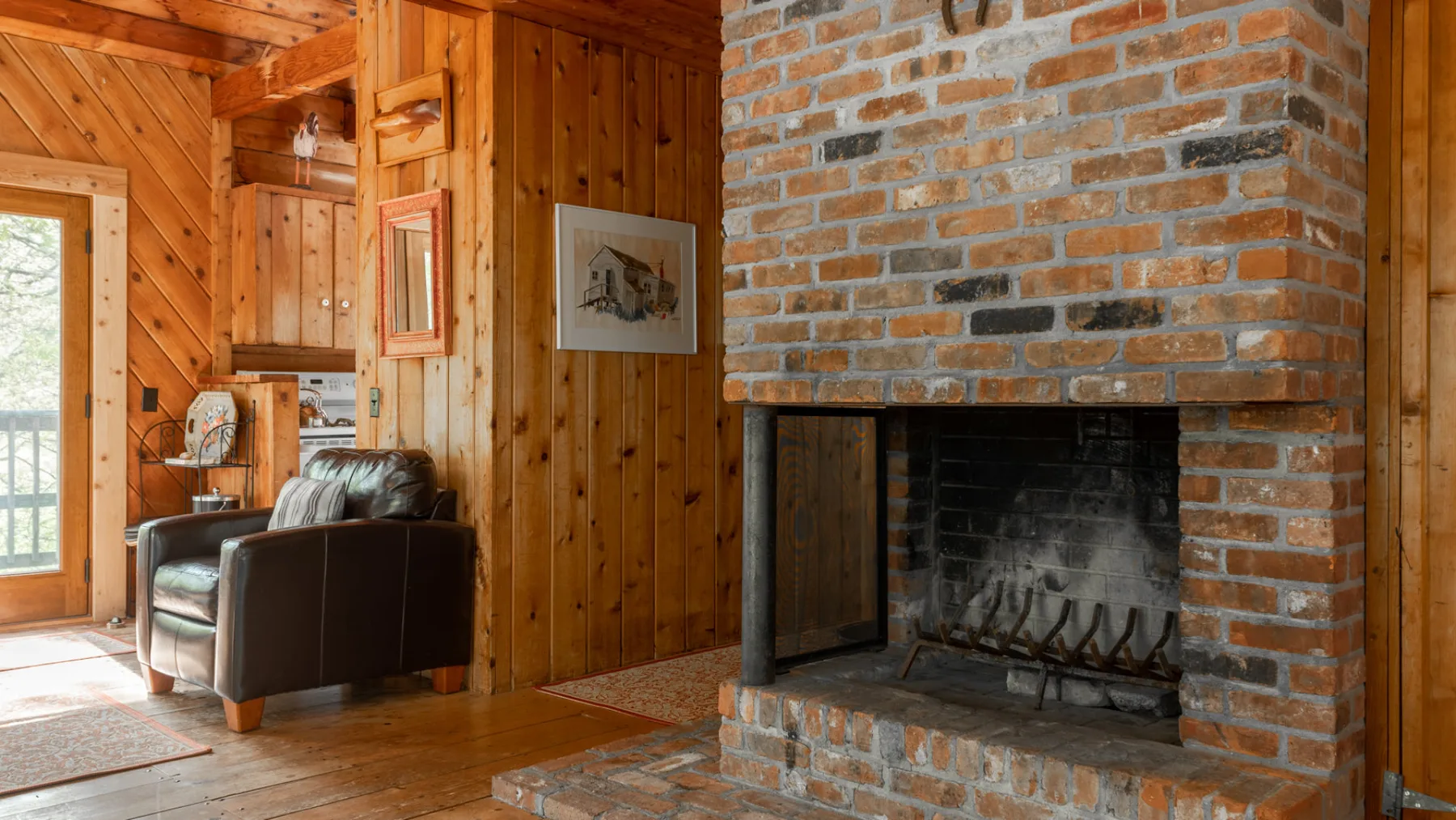 Una sala revestida de madera con asientos junto a una chimenea de ladrillo.