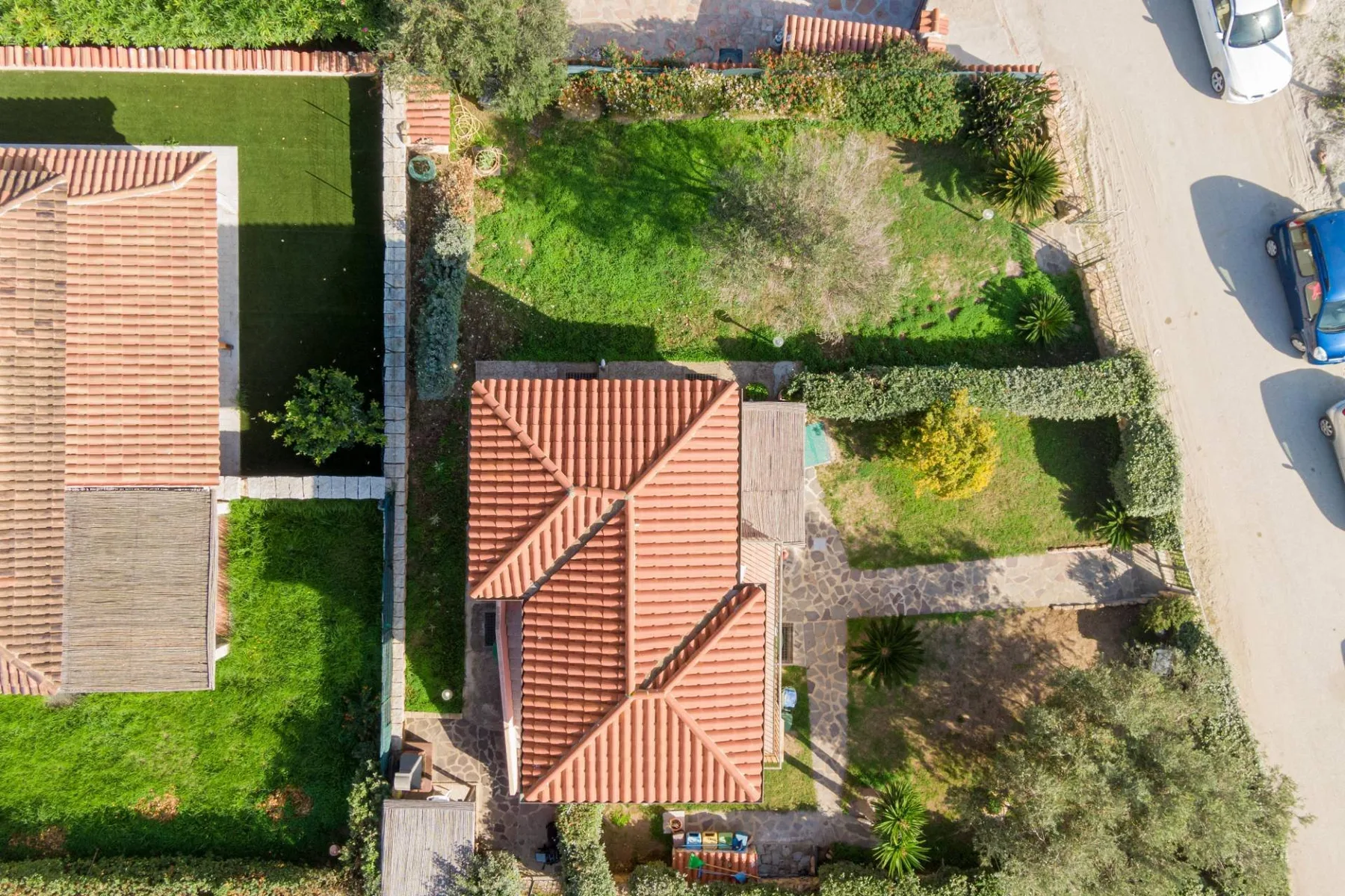 Una vista aérea muestra una casa rodeada de jardines y senderos de piedra.