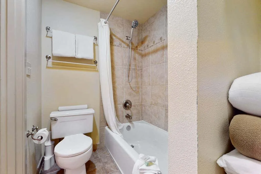 Un baño con bañera, ducha y toallero.