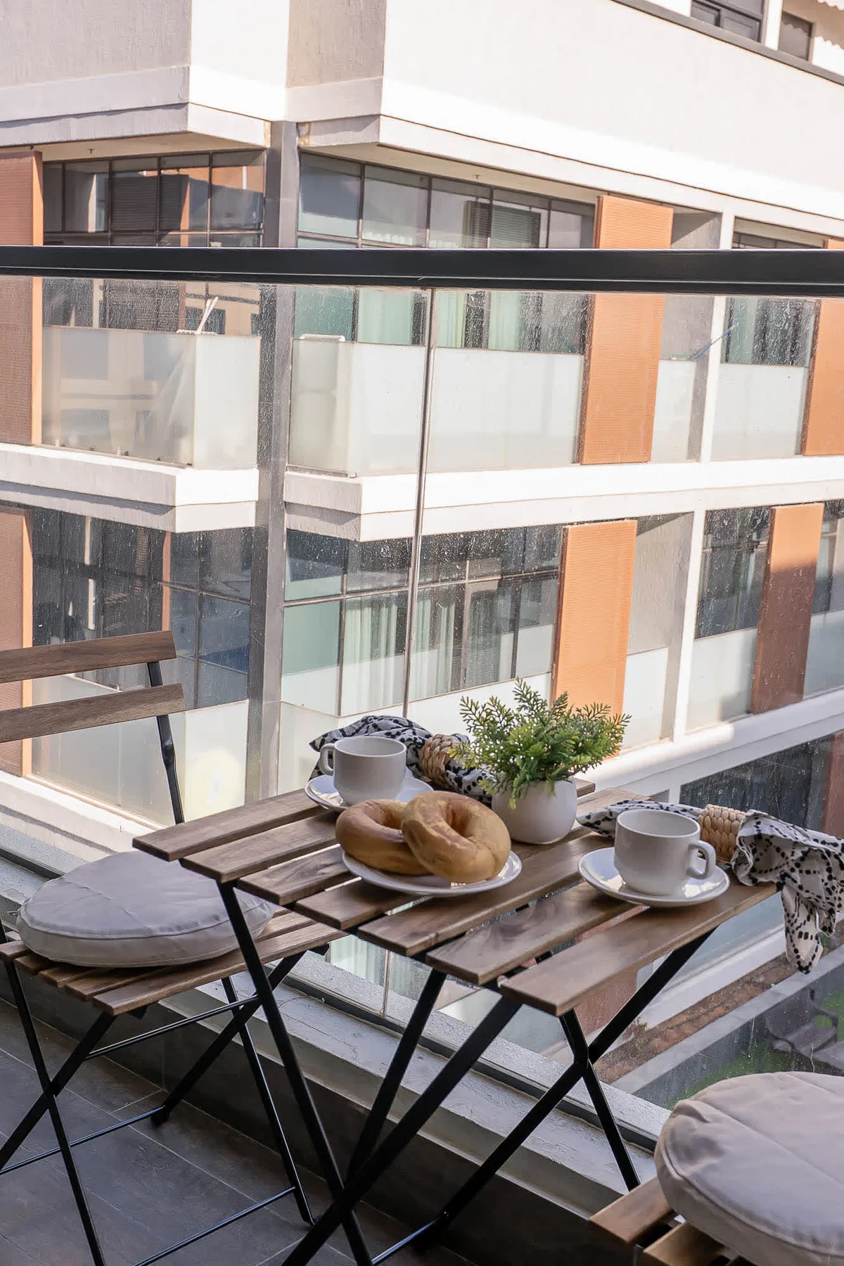 A small balcony seating area with a folding table set for coffee.