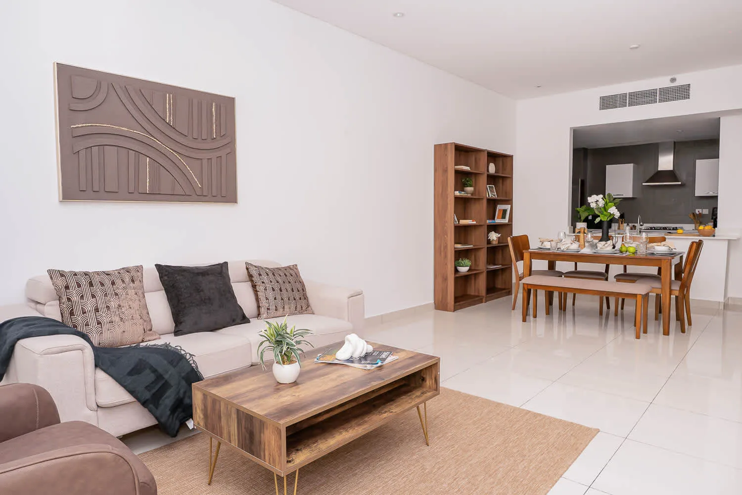 A bright living and dining area features a sofa, coffee table, and dining table.