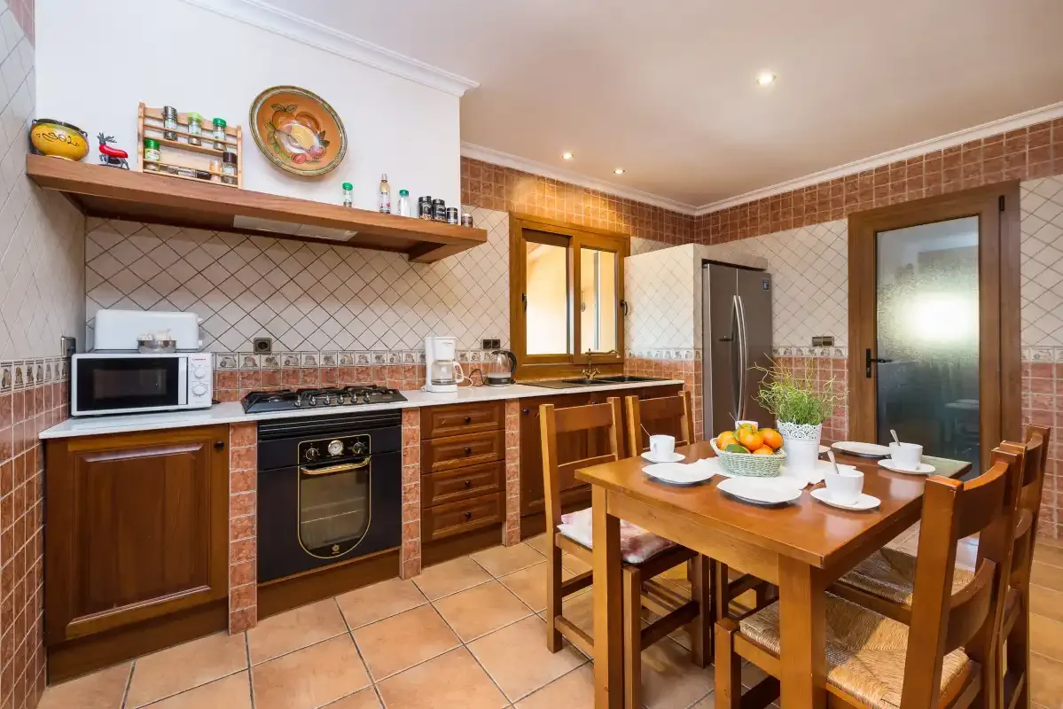 A spacious kitchen with wooden cabinets and a dining table.