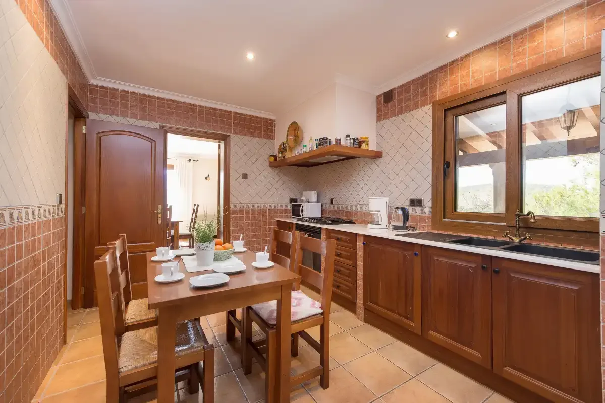 A tiled kitchen and dining area with wooden cabinets and a set table.