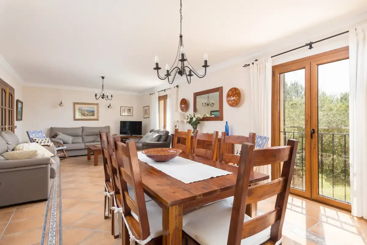 A dining area with a wooden table and seating beside glass doors.