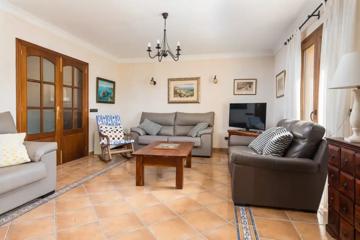A living room with seating, a coffee table, and a television.