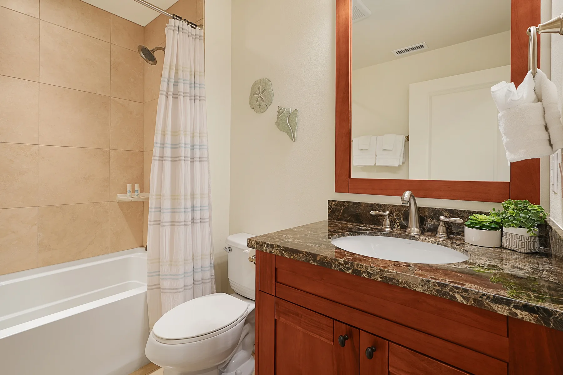 Un baño con bañera, inodoro y tocador con lavabo.