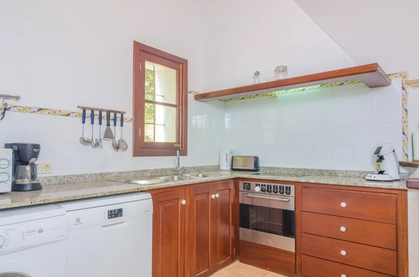A kitchen with wooden cabinets, a countertop, and an oven.