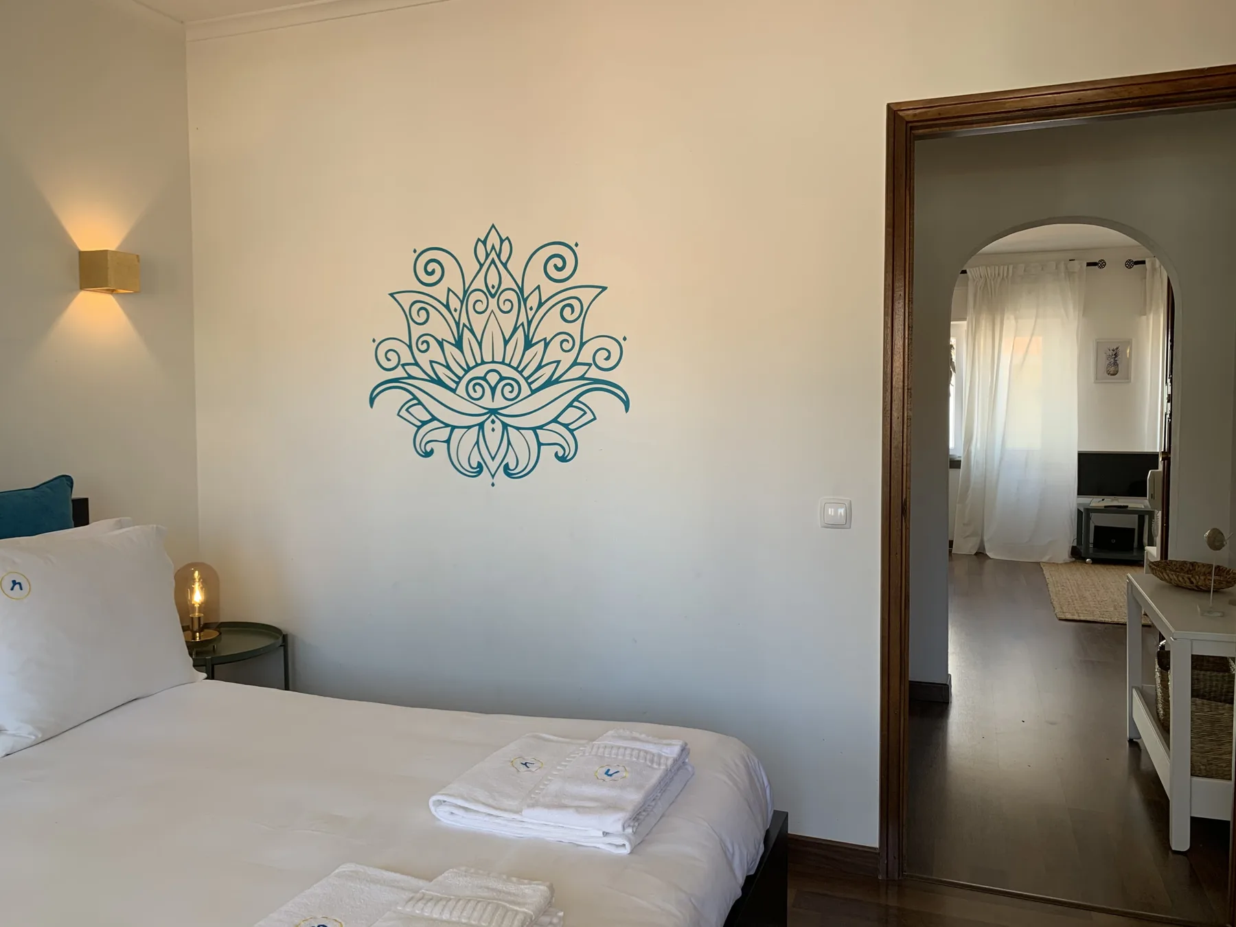 A bedroom with a bed and a decorative wall design.
