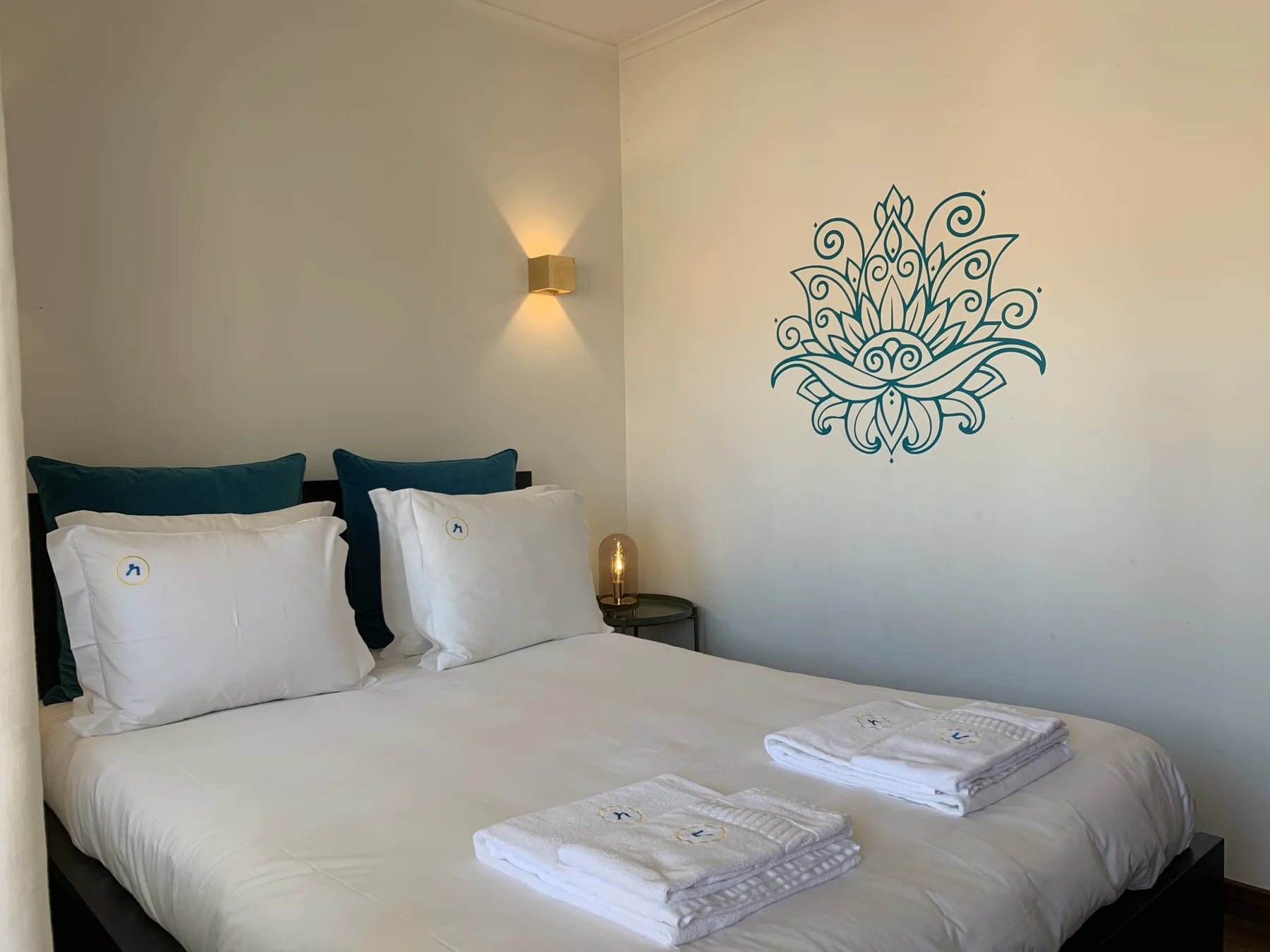 A bedroom with a neatly made bed and decorative wall art.