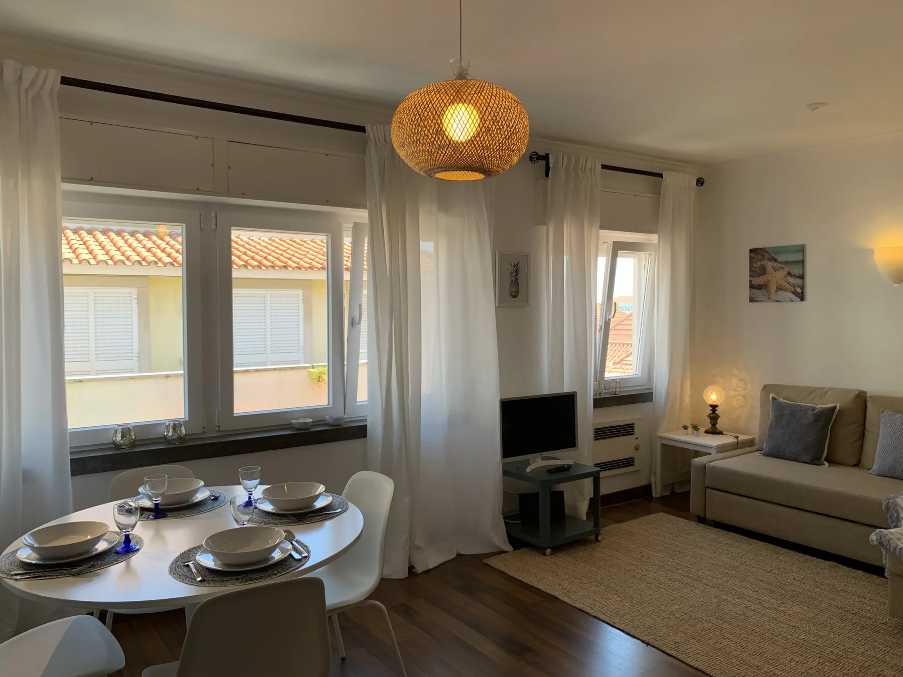 A bright living and dining area with a set table and seating.