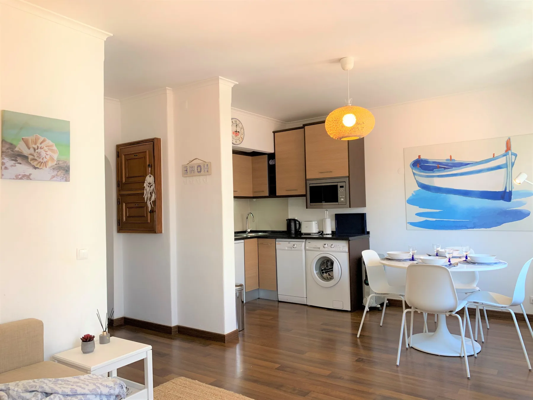 Un comedor con mesa y sillas está junto a una cocina compacta.